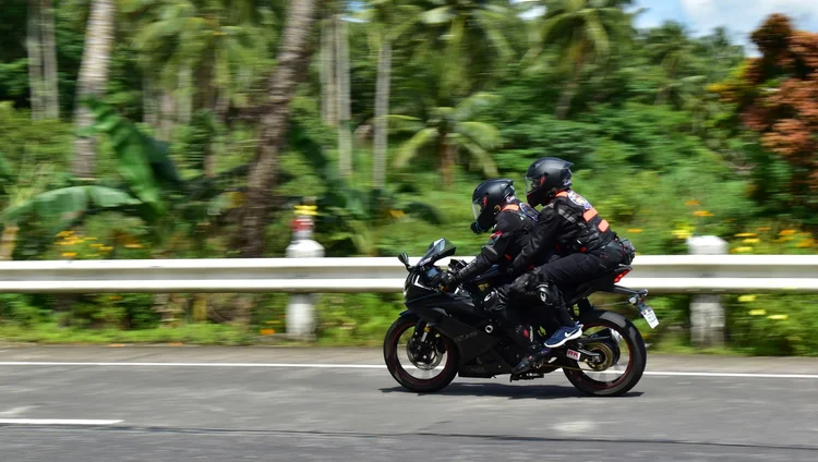 CALABARZON Moto Rider Destinations Two motorcycle riders, male and female, speeding on the highway