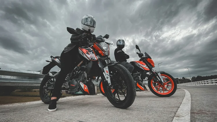 Top 4 Things to Consider Before Buying a Motorcycle in the Philippines Two motorcycle riders, male and female, parked on the street